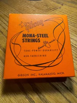 VINTAGE GIBSON MONA STEEL STRING BOX WITH ONE STRING IN ORIGINAL PACKAGING