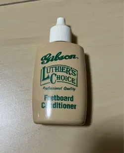 A SET OF GUITAR GIBSON FRETBOARD CONDITIONER AND PICK