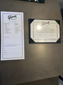 GIBSON ACOUSTIC BLACK CERTIFICATE OF AUTHENTICITY AND CHECKLIST.