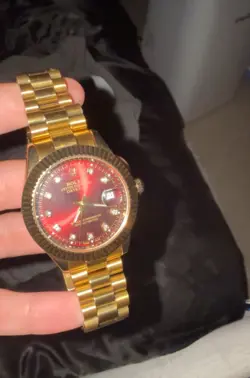 ROLEX GOLD WATCH WITH RED DIAL AND DATE INDICATORS