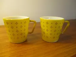 A PAIR OF VTG.PYREX 1410 COFFEE CUPS. MUSTARD YELLOW. 10 OZ. FOULARD STARBURST.